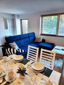 ein Wohnzimmer mit einem Tisch und einem blauen Sofa in der Unterkunft Apartament LABA in Sosnowka