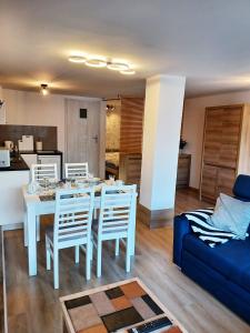 - un salon avec une table et un canapé bleu dans l'établissement Apartament LABA, à Sosnówka