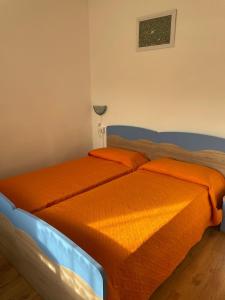 a bedroom with two beds with orange sheets at Casa Zanoni in Nago-Torbole