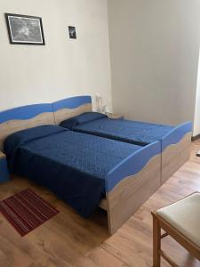 a bedroom with a blue bed in a room at Casa Zanoni in Nago-Torbole