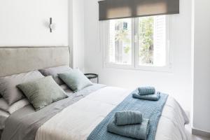 una camera da letto con un letto con due cuscini e una finestra di A bright Nest in the heart of Plaka ad Atene