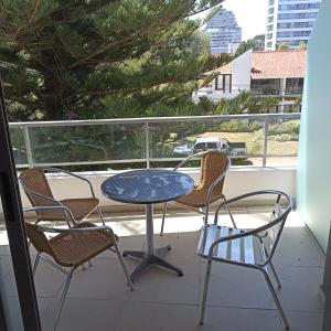 stół i krzesła na balkonie z widokiem w obiekcie Cerca de la brava con buenos servicios w mieście Punta del Este