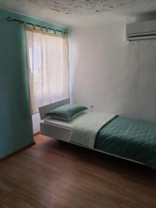a bedroom with a bed and a window with a green pillow at Hostel Martin in Koper