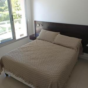 1 cama en un dormitorio con ventana grande en Cerca de la brava con buenos servicios, en Punta del Este