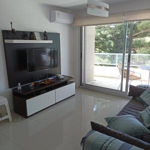 sala de estar con TV de pantalla plana y sofá en Cerca de la brava con buenos servicios, en Punta del Este