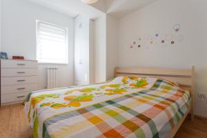 a bedroom with a bed with a colorful blanket at Apartment Skopje in Skopje
