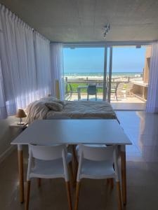 1 dormitorio con 1 cama y 1 mesa con 2 sillas en Linda Bay Beach & Resort Studio 304 en Mar de las Pampas
