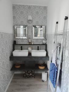a bathroom with two sinks and two mirrors at La Ménardière "Tranquilitatis" Chambre double petit déjeuner compris in Corseul