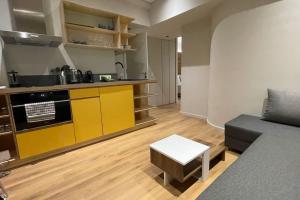 a living room with a couch and a kitchen at Athenian Aura Kolonaki - Feel Athens City Center in Athens