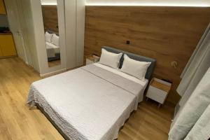 1 dormitorio con 1 cama blanca grande y espejo en Athenian Aura Kolonaki - Feel Athens City Center, en Atenas