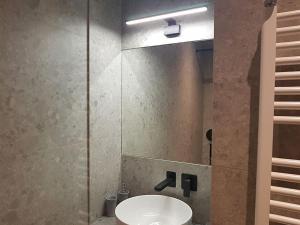 W łazience znajduje się umywalka i lustro. w obiekcie Athenian Aura Kolonaki - Feel Athens City Center w Atenach