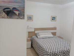 sypialnia z łóżkiem i obrazem łodzi w obiekcie Torres Montecarlo Apartmento con vistas al mar w mieście Benidorm +25 zdjęć