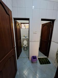La salle de bains est pourvue de toilettes, d'une fenêtre et d'une porte. dans l'établissement Villa Jane, à Arusha