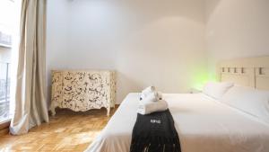 Un dormitorio con una cama blanca con una toalla encima. en Los Balcones de Maritxu, en Toledo