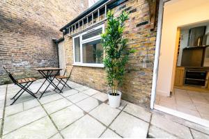 Un patio con una planta en una maceta junto a una pared de ladrillos. en Stylish 2 Bedrooms Little Venice - 44, en Londres