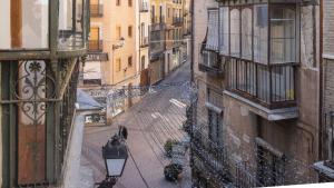 un callejón en una ciudad con una persona caminando por la calle en Los Balcones de Maritxu, en Toledo
