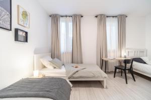 1 dormitorio con 2 camas, escritorio y mesa en Villa Gaj, en Milna