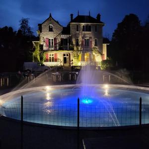 a mansion with a fountain in front of a house at Le Pavillon de St Agnan in Hautefort