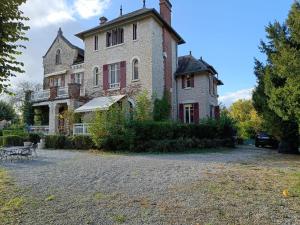 a large brick house with a patio in front of it at Le Pavillon de St Agnan in Hautefort