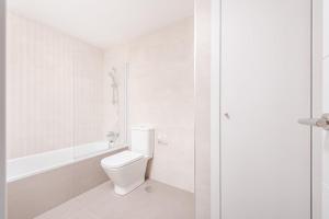 a white bathroom with a toilet and a bath tub at Los Robles Stylish & Modern 1 Bedroom Apartment in Madrid Conde Orgaz in Madrid