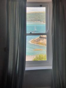 a window in a room with a view of the ocean at Arvonia sleeps 7, sea views, dog friendly in New Quay