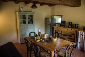 cocina con mesa de madera con sillas y nevera en Gîte de la Lioterie en Maillet