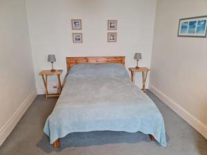 a bedroom with a large bed with two tables at Arvonia sleeps 7, sea views, dog friendly in New Quay
