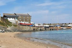 a beach with a house and boats in a harbor at Arvonia sleeps 7, sea views, dog friendly in New Quay