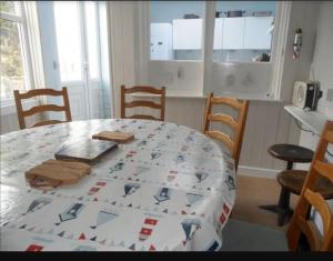 a kitchen with a table and chairs with a tablecloth on it at Arvonia sleeps 7, sea views, dog friendly in New Quay