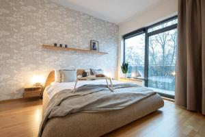1 dormitorio con cama grande y ventana grande en 2 Bedroom Apt, 2 Garage Spots & Balconies, Self Check-in, by Cohost, en Druskininkai