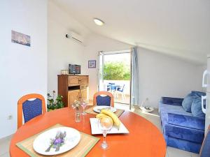 uma sala de jantar com uma mesa e um sofá azul em Apartments Bruno em Tribunj