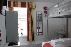 ein Schlafzimmer mit einem Bett, einem Waschbecken und einem Fenster in der Unterkunft Backpackers Blackpool Hotel & Suites in Blackpool + 140 Fotos