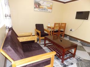 a living room with wooden furniture and a table at Cloud9 Suites in Kitale