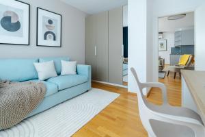 a living room with a blue couch and a table at Business & Family Ambiente Apartments in Bratislava +185 photos