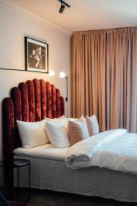 a bedroom with a large bed with a red headboard at Quality Hotel Carlia in Uddevalla