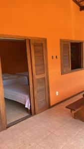 Un dormitorio con una puerta abierta con una cama. en Pousada Sunset, en Itacaré