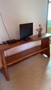 a wooden desk with a television on top of it at Pousada Sunset in Itacaré