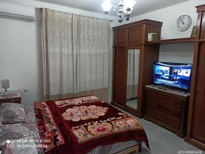 a bedroom with a bed and a flat screen tv at عين النعجة جسر قسنطينة الجزائر Ain Naadja 