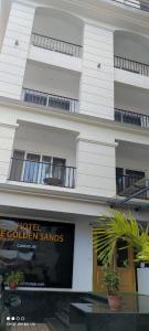 un grand bâtiment blanc avec un hôtel appelé le sable doré dans l'établissement Hotel The Golden Sands, à Calangute