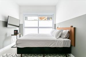 um quarto com uma cama grande e uma janela em Apartamentos completos ao lado da UFSC - NAVONA em Florianópolis