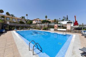 uma grande piscina com água azul em Chalet Santa Ana 2 by VillaGranCanaria em Playa del Inglés