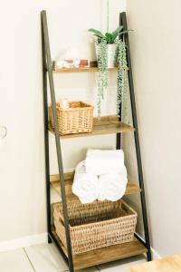 a ladder shelf filled with baskets and towels at St George's Guest House in Tzaneen