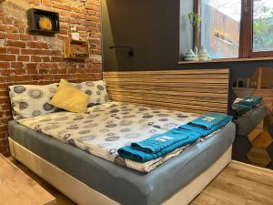 een bed in een kamer met een bakstenen muur bij City Garden Studio in Plovdiv