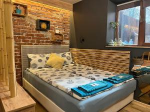 a bed in a room with a brick wall at City Garden Studio in Plovdiv