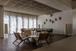uma sala de jantar com mesas e cadeiras e uma grande janela em Belambra Clubs Presqu'île De Giens - Riviera Beach Club em Hyères