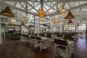 une salle à manger avec des tables, des chaises et des lustres dans l'établissement Belambra Clubs Presqu'île De Giens - Riviera Beach Club, à Hyères