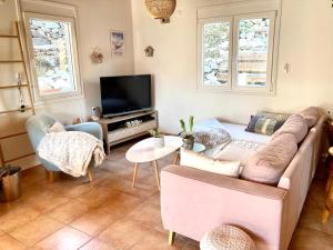 a living room with a couch and a tv at Le Cocon de l'Epicléa, Chorges, entre lac et montagnes in Chorges