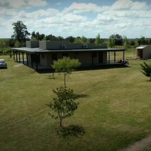 une maison dans un champ avec un arbre dans la cour dans l'établissement Bahía de cimarrones, à Dolores
