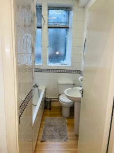 a bathroom with a tub and a toilet and a sink at Amazing 2 bedroom apartment in London