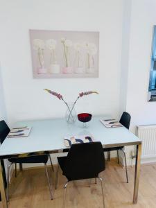 a white table with chairs and vases on a wall at Amazing 2 bedroom apartment in London